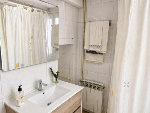 a white bathroom with a sink and a shower at Masia Pau Prat in Lliçà d'Amunt