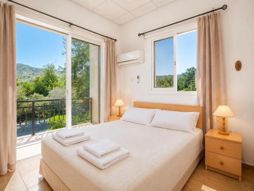 a bedroom with a bed and a large window at Villa Sotiroula in Kato Yialia