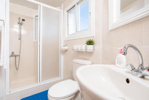 a bathroom with a toilet and a sink and a shower at Villa Sotiroula in Kato Yialia
