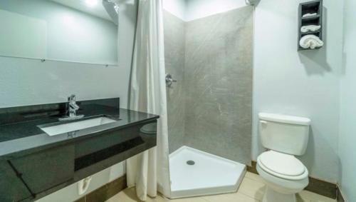 a bathroom with a toilet and a sink and a shower at Xpress Inn & Extended Stays in Marshall