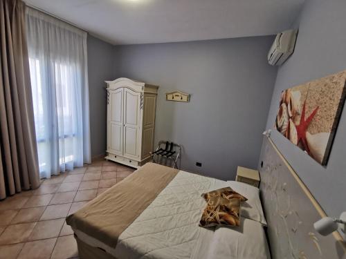 a bedroom with a bed and a large window at Il Giardino del Sol in San Vito lo Capo