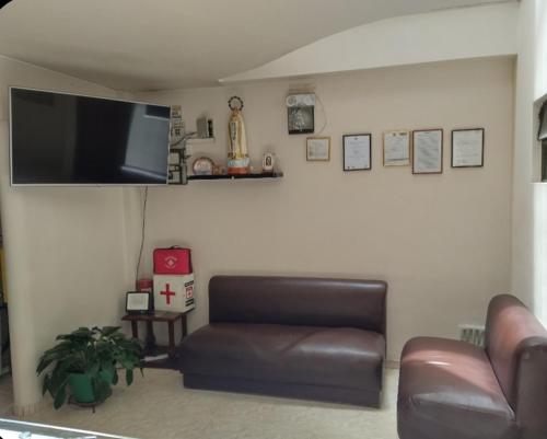 a living room with a couch and a flat screen tv at Hotel Surandino Fátima in Pasto