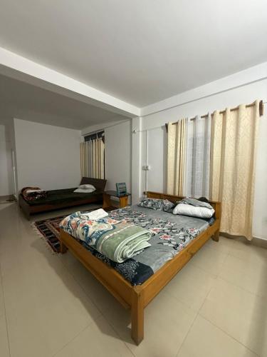 a bedroom with a large bed and a window at The Blooming Tulip in Shergaon