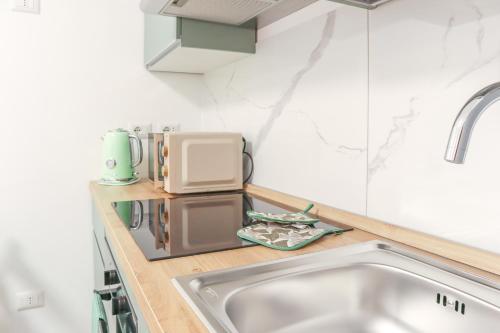 a kitchen with a sink and a microwave at La casetta in corte in Cormano