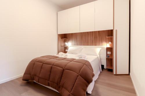 a bedroom with a large bed with a brown ottoman at La casetta in corte in Cormano