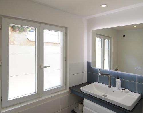 a bathroom with a sink and a mirror at Le Petit Musée in Loches
