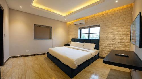 a bedroom with a bed and a desk and a window at Citistay Apartments in Abuja