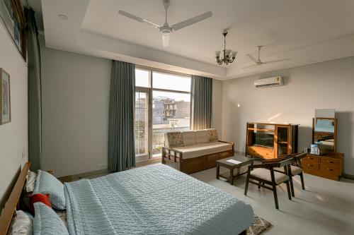 a bedroom with a bed and a desk and a window at IT City Luxe Homestay-Secure & Comfortable Stay in Mohali in Mohali