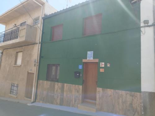 a green building with a door on the side of it at CASA GORDON in Navaluenga