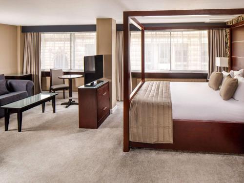 a hotel room with a bed and a living room at Mercure Glasgow City Hotel in Glasgow
