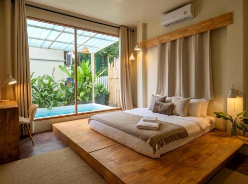 a bedroom with a large bed and a large window at Thara Pearl Villa in Ko Phangan
