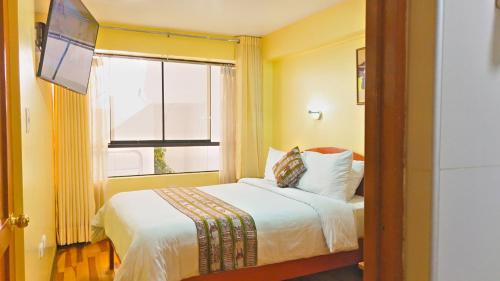 a hotel room with a bed and a window at Hawka Inka hotel cusco in Cusco