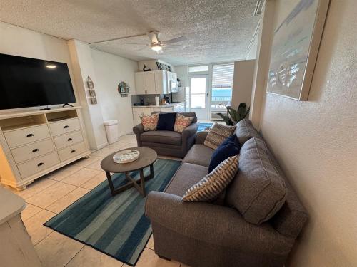 a living room with a couch and a tv at Direct ocean front view 1 bedroom 2 Pools in Daytona Beach