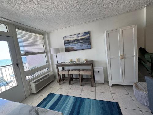 a living room with a desk and a table at Direct ocean front view 1 bedroom 2 Pools in Daytona Beach