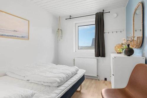 a white bedroom with a bed and a window at bl1192-Blokhus-Holstvej-7 in Blokhus