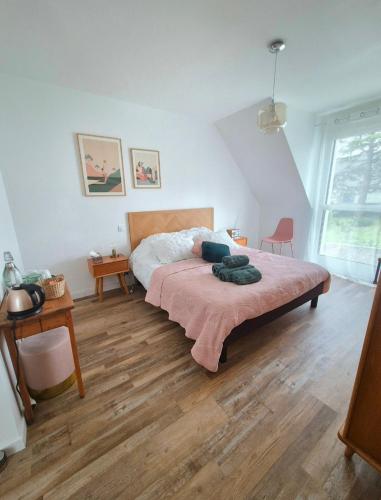 a bedroom with a bed and a wooden floor at Les Ganivelles in Belz