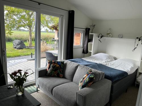 a living room with a couch and a bed at Mariafarm Chalets in Zevenbergen
