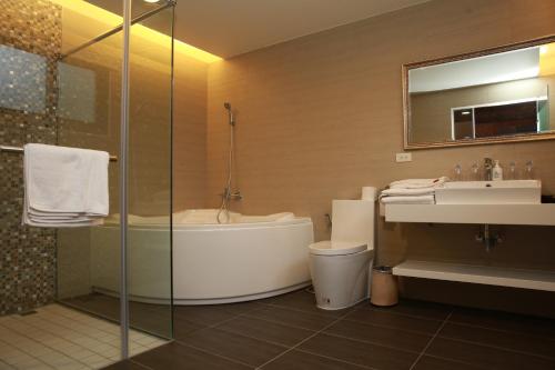 a bathroom with a tub and a toilet and a sink at Old House Homestay in Sanxing