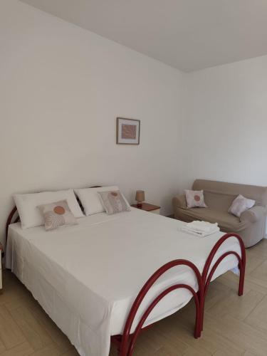 a bedroom with a large white bed and a couch at Passo lento in Leverano