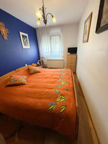 a bedroom with a large bed with an orange blanket at Apartamento Liencres in Liencres