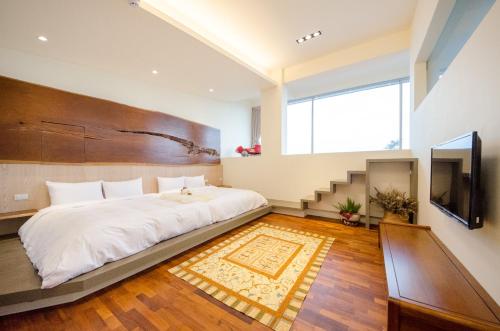 a bedroom with a large bed and a television at WMS Villa in Dongshan