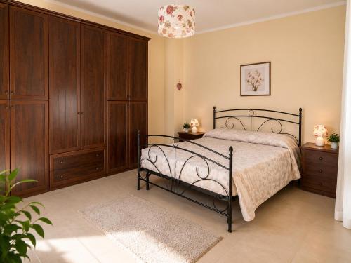 a bedroom with a bed and wooden cabinets at Casa vacanze "Ellen" - AAUT in Bianchi