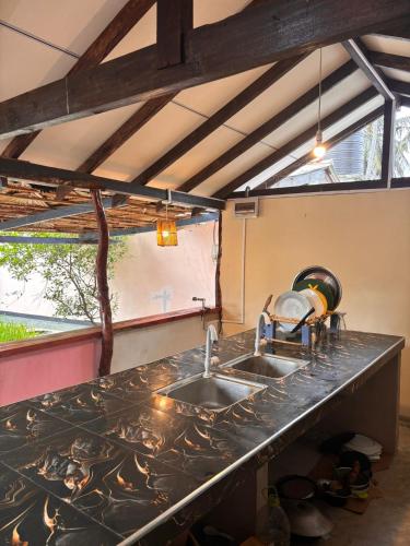 a kitchen with a sink and a counter top at AAA Happy Hostel in Arugam Bay