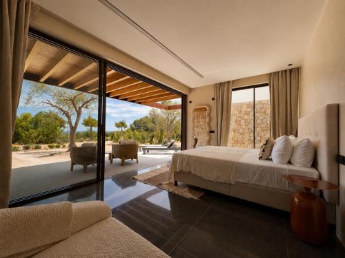 a bedroom with a bed and a living room at Can Skye in Sant Carles de Peralta