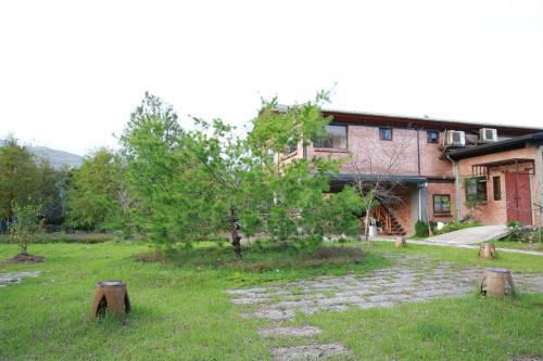 a house with a yard with trees and a building at Old House Homestay in Sanxing