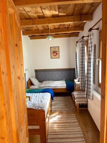 two beds in a room with wooden ceilings at Anna Lak in Magyarszombatfa