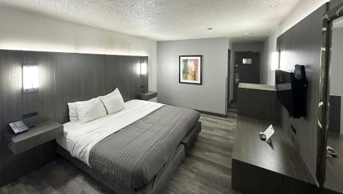 a hotel room with a bed and a television at Magnuson Hotel Fort Wayne North - Coliseum in Fort Wayne