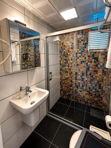 a bathroom with a sink and a shower at Calis Hotel in Çeşme