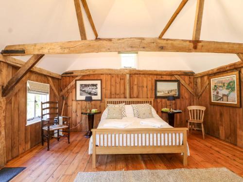 a bedroom with a bed in a room with wooden walls at The Granary in Petworth