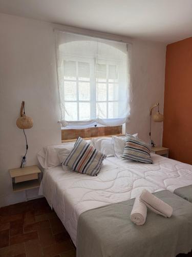 a bedroom with two twin beds with a window at El Rincón del Tuno in Carmona