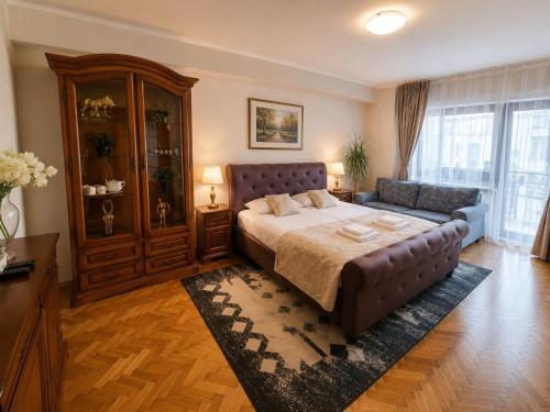 a large bedroom with a bed and a couch at COZY PANORAMA Flat in Alba Iulia