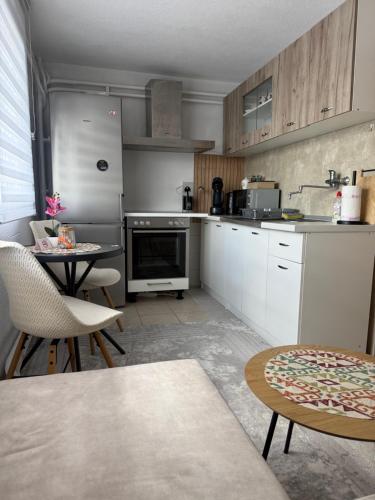 a kitchen with white appliances and a table and chairs at Apartman Rejjan in Zenica
