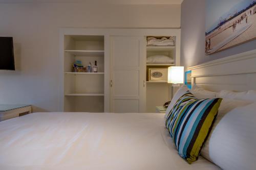 a bedroom with a white bed with a pillow on it at Bayside Hotel in Los Angeles