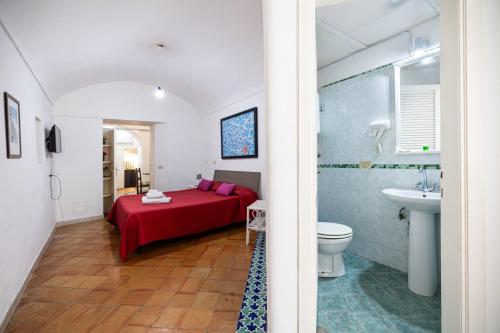 a bedroom with a bed and a bathroom with a sink at Casa Colette in Anacapri