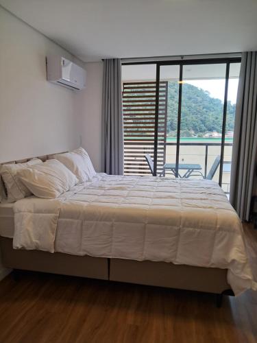 a bedroom with a bed and a large window at Grand Reserva Granja Brasil in Araras Petropolis