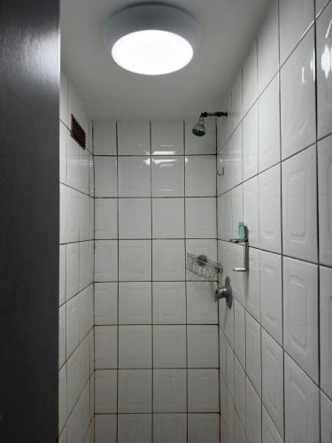 a bathroom with a white tiled shower with a light at 18 Budget Inn in London