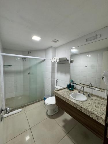 a bathroom with a shower and a toilet and a sink at Praiano Flat Tambaú in João Pessoa