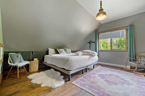 a bedroom with a bed and a window and a rug at Rustic Chalet & Serenity in Mont Blanc in Saint-Faustin
