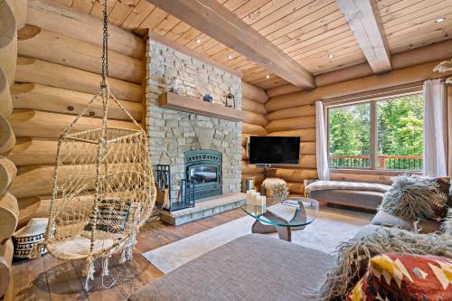 a living room with a fireplace and a swing at Rustic Chalet & Serenity in Mont Blanc in Saint-Faustin