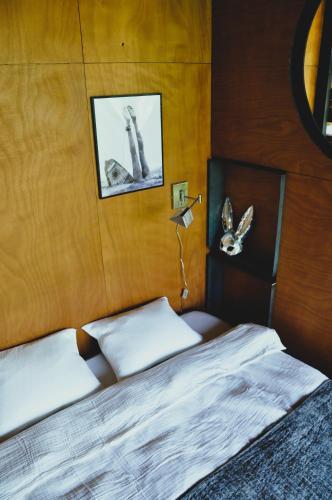 a bedroom with a bed and a wooden wall at PARO cabin in Ignalina