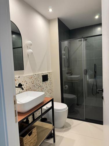 a bathroom with a sink and a toilet and a shower at Stylish Designer Apartment in Mellieħa