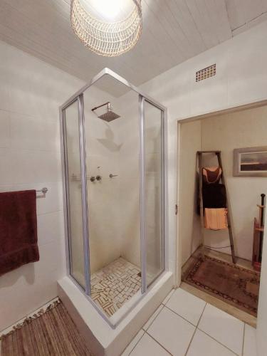 a shower with a glass door in a bathroom at Good Vibes in Uniondale