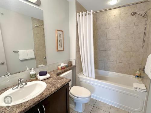 a bathroom with a sink and a toilet and a tub at Silver Rock by StayIn in Fernie