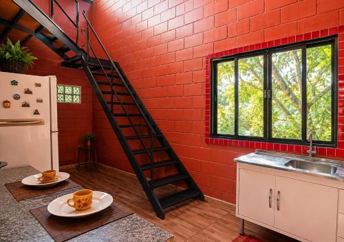 a kitchen with a spiral staircase in a red brick wall at Bosque da Lua - Suite with 2 bathrooms - Up to 5 guests in Itupeva