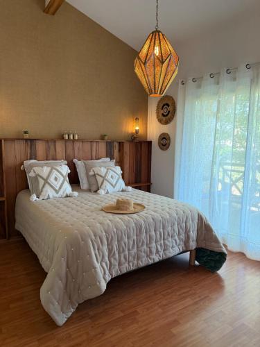 a bedroom with a large bed with a white comforter at Le Gahignon in Lanton