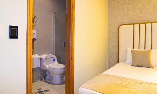 ein kleines Badezimmer mit Toilette und Bett in der Unterkunft Zumo hotel lorica in Lorica